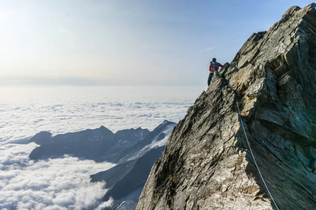 alpinistre gravissant une montagne
