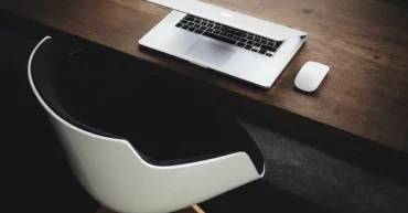 bureau de travail avec une chaise devant un ordinateur portable